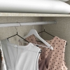 Detalhe do cabideiro do armário Sirius com peças de roupa – Vicawu